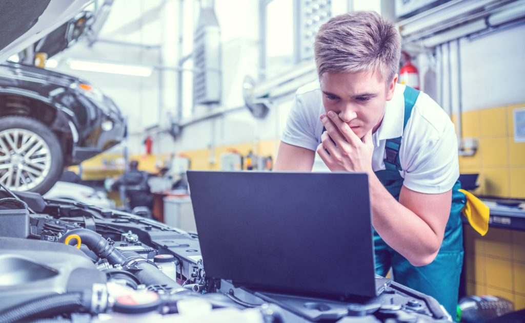 Mechanic checking a computer during a diagnostics inspection - Car Diagnostics Ely